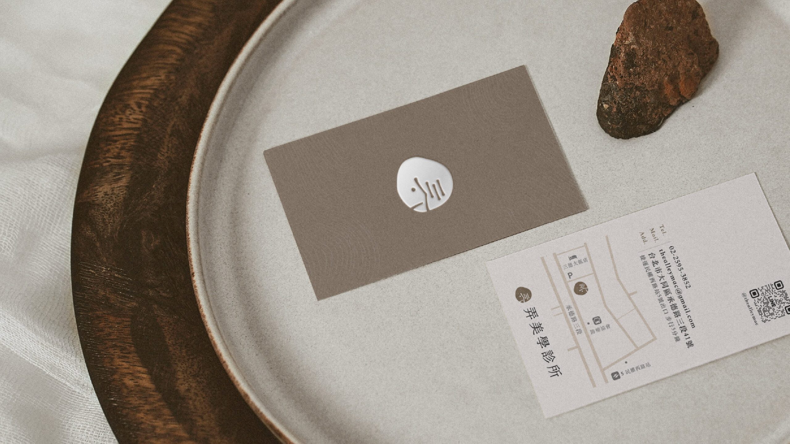 弄美學診所名片設計，正面為品牌色背景與珍珠色燙金LOGO，背面資訊清晰排版