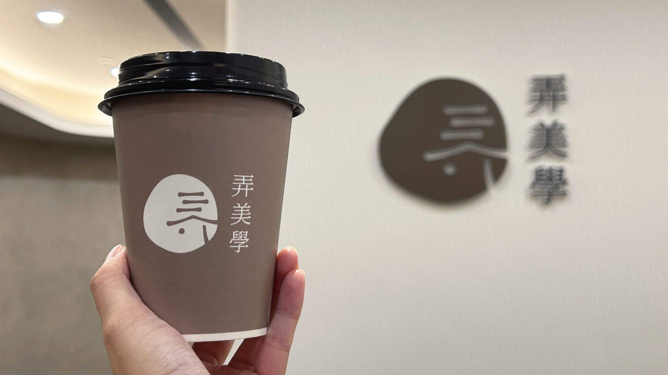 弄美學咖啡紙杯於診所形象牆前展示