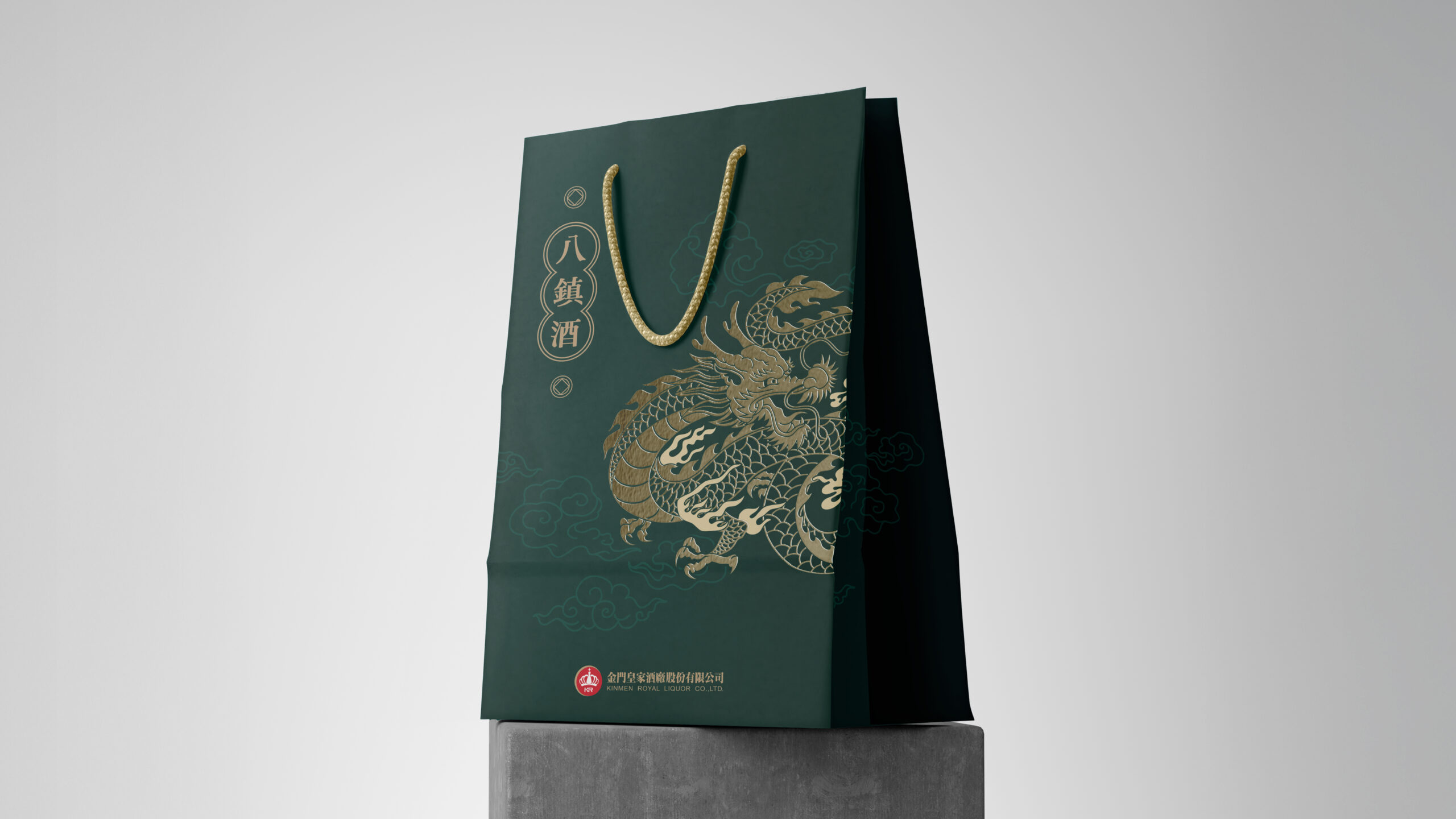 八鎮酒龍首紀念酒手提紙袋，墨綠底色配金色提繩與燙金龍紋